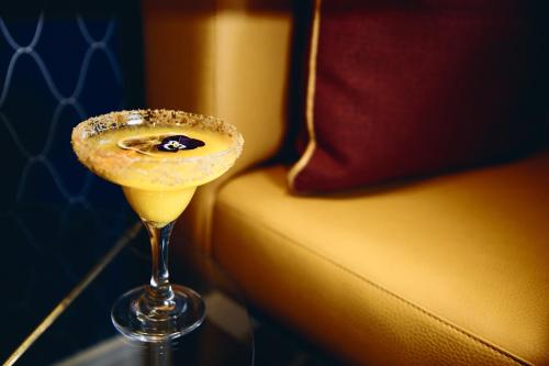 a drink in a martini glass next to a couch at Palacio Avenida in Palma de Mallorca