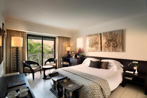 a hotel room with a bed and a balcony at Labadi Beach Hotel in Accra