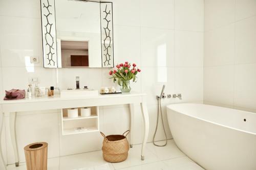 a white bath tub sitting next to a white sink at UR Palacio Avenida in Palma de Mallorca