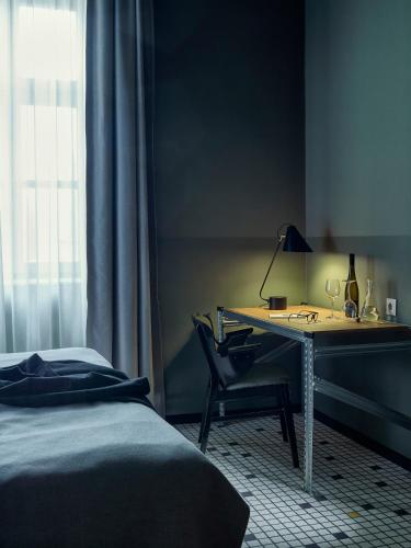 a bedroom with a desk with a bed and a lamp at Neptun Badacsony in Badacsonytomaj