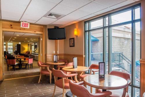 a restaurant with tables and chairs and a tv at Comfort Suites Near Casinos in Norwich