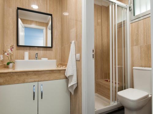 a bathroom with a sink and a toilet and a mirror at Amazónico Playa de Mogán in Puerto de Mogán