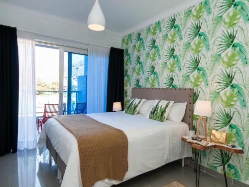 a bedroom with a bed with a tropical wallpaper at Amazónico Playa de Mogán in Puerto de Mogán