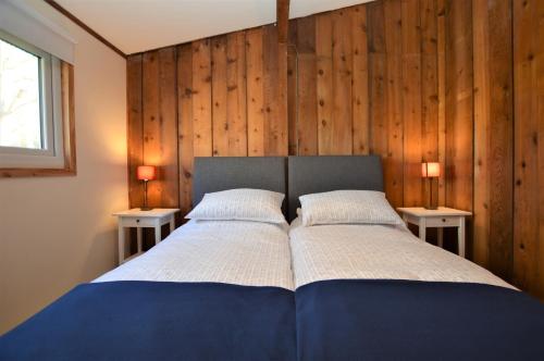 a bedroom with a blue bed with two night stands at Scallopshell Lodge in Otter Ferry