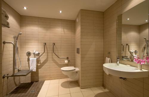 a bathroom with a toilet and a sink at Labadi Beach Hotel in Accra