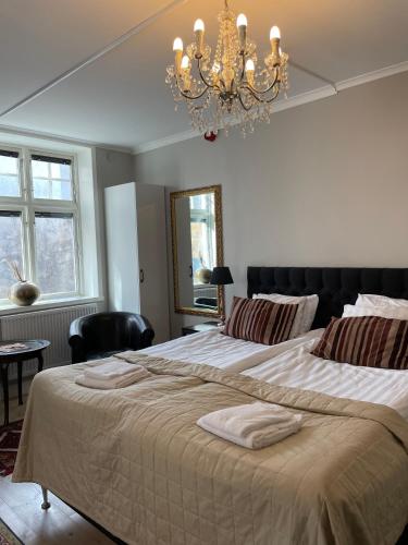 a bedroom with a large bed with a chandelier at Börsen Annex in Visby