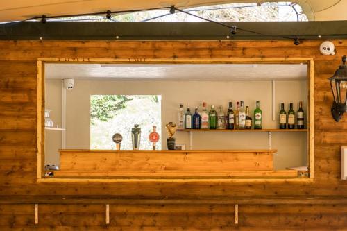 a wooden shelf with bottles and bottles on top of it at The Lodge at Woodenbridge in Arklow