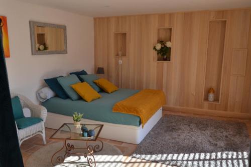 une chambre avec un lit avec des oreillers bleus et jaunes dans l'établissement LA VIGNERAIE, à Albiac