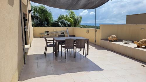 patio con mesa y sillas en el balcón en Assaf's place - המקום של אסף, en Aẖihud