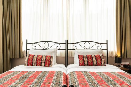 a bedroom with two beds with pillows at Hotel Flower in Tbilisi City