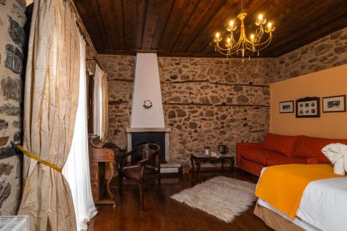 a bedroom with a bed and a fireplace at Proselinos in Dhimitsana