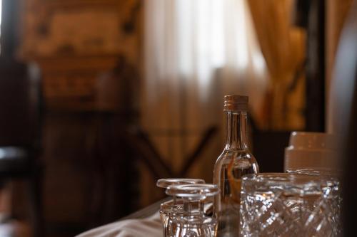 a bottle and glasses sitting on a table at Proselinos in Dhimitsana