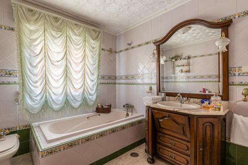 y baño con bañera, lavabo y espejo. en BNBHolder Deluxe Cottage TITULCIA, en Titulcia