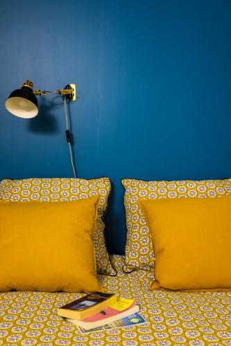 - un lit avec deux oreillers, une lampe et un livre dans l'établissement Appart Cosy entre vieux port et marché central, à La Rochelle