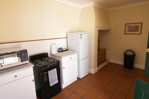 a kitchen with a stove and a refrigerator at De Kothuize 7 in Graaff-Reinet