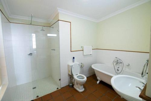 a bathroom with a tub and a toilet and a sink at De Kothuize 7 in Graaff-Reinet