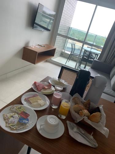 a table with plates of food and drinks on it at SALINAS EXCLUSIVE RESORT in Salinópolis
