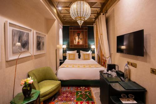 una habitación de hotel con una cama grande y una silla en Elegancia Riad Boutique & SPA en Marrakech