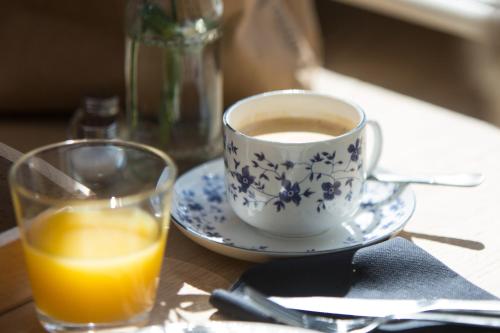a cup of coffee and a glass of orange juice at Vakantiewoning De Beiert in Delden