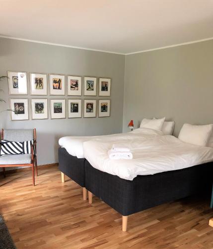 a bedroom with a large bed and pictures on the wall at Villa Maria Garden Cottages, Helsingborg in Helsingborg