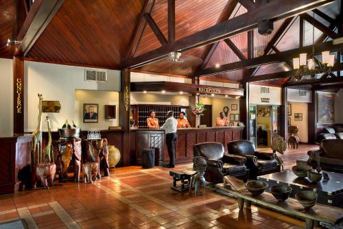 a lobby with a bar and people standing at a counter at Labadi Beach Hotel in Accra