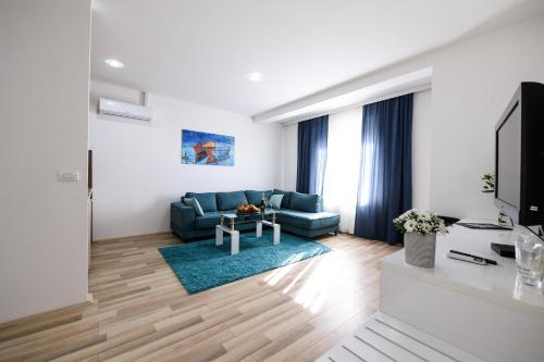 a living room with a blue couch and a tv at River Inn in Stari Banovci