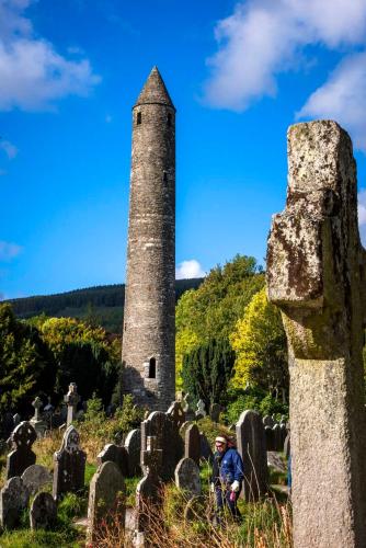 a man standing in a cemetery with a tower at The Lodge at Woodenbridge in Arklow