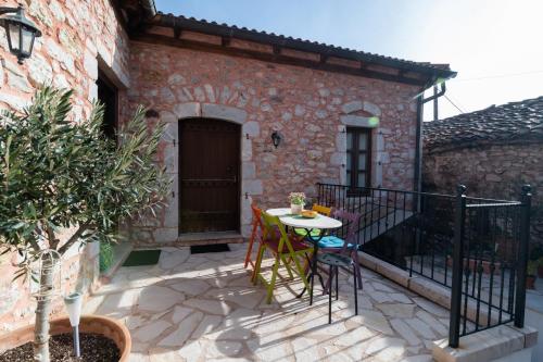 a patio with a table and chairs in front of a building at Proselinos in Dhimitsana