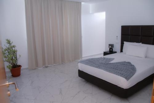 a bedroom with a large bed with a black headboard at Hotel Por Do Sol in Tarrafal