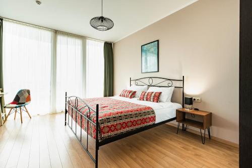 a bedroom with a bed and a desk and a chair at Hotel Flower in Tbilisi City