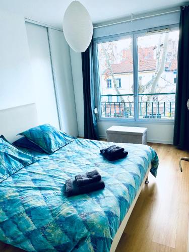 une chambre avec un lit et une grande fenêtre dans l'établissement Chez Marie, à Lyon