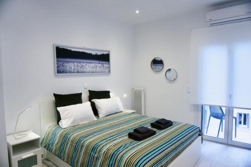 biała sypialnia z łóżkiem z paskiem w obiekcie Stunning Cozy Apartment in Athens w Atenach