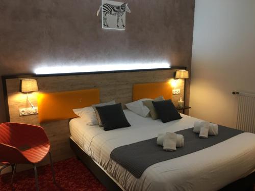 a bedroom with a large bed with two pillows at Hôtel Saint Albert in Sarlat-la-Canéda