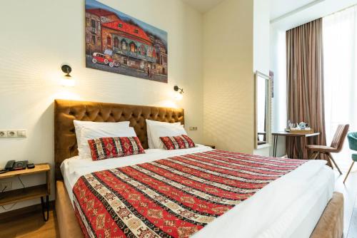 a bedroom with a large bed with a colorful blanket at Hotel Flower in Tbilisi City