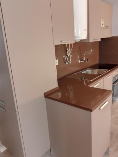 a kitchen with white cabinets and a sink at CASA DAS QUATRO CABEÇAS in Setúbal