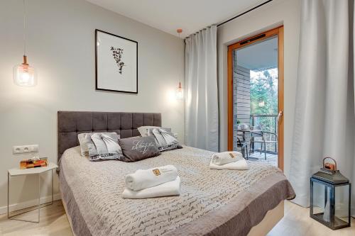 a bedroom with a bed with two towels on it at 4 Seasons Jelitkowo + Beach in Gdańsk