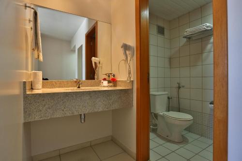 a bathroom with a toilet, sink, and shower at Comfort Hotel Goiânia in Goiânia