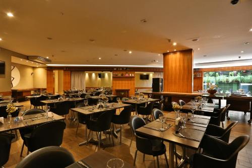 a restaurant with tables and chairs in a room at Comfort Hotel Goiânia in Goiânia