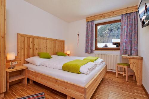 Un dormitorio con una cama grande y una ventana en am Sonnhof, en Längenfeld
