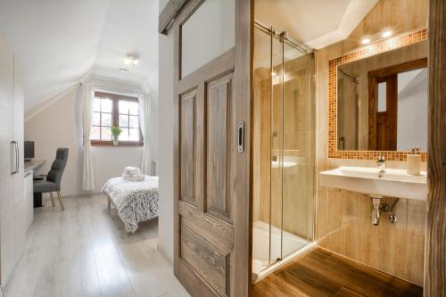 een badkamer met een douche, een wastafel en een spiegel bij Biały Domek in Karpacz