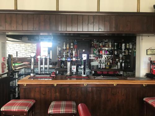 a bar with a lot of bottles of alcohol at The Ball Alley in Stanley