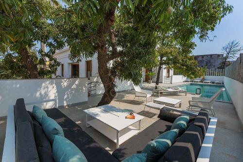 a patio with a couch and a table and a pool at La Villa in Puducherry