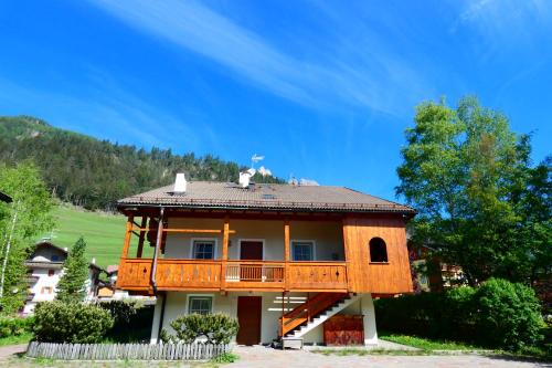 a house with a balcony on top of it at Casa El Tobià in Pozza di Fassa