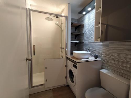 une salle de bain avec une machine à laver et un lavabo dans l'établissement Atlantide Angloye, à Anglet