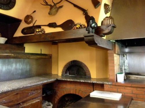 Il comprend une cuisine équipée d'un four en briques et d'une cheminée. dans l'établissement Albergo Ristorante Da Carlino, à Castelnuovo di Garfagnana