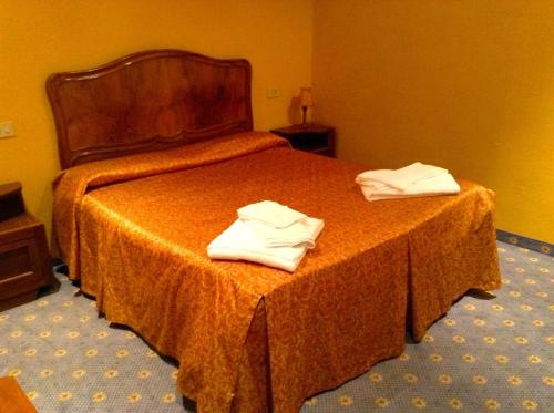 Albergo Ristorante Da Carlino في كاستيلنيوفو دي غارفانيانا: غرفة فندق عليها سرير وفوط