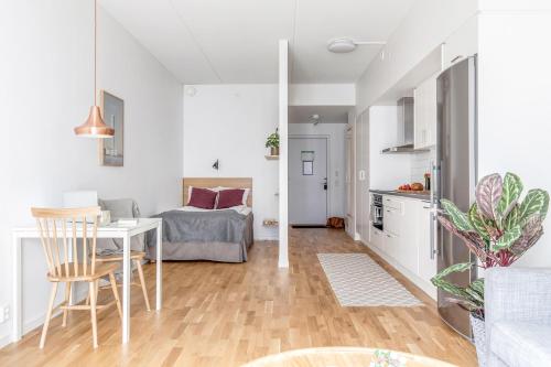 a kitchen and living room with a table and a bed at Apartments Malmö in Malmö
