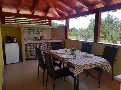 uma cozinha com mesa e cadeiras e uma cozinha com mesa e espreguiçadeira em Holiday house in Pakoštane with sea view, terrace, air conditioning, Wi-Fi (4852-1) em Pakoštane