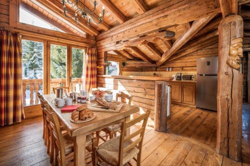 une cuisine avec une table et des chaises dans une cabine dans l'établissement Madame Vacances Chalet Elliot Ouest, à La Tania