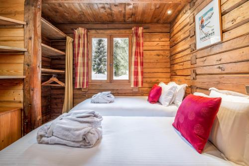 a bedroom with two beds in a log cabin at Madame Vacances Chalet Elliot Ouest in La Tania